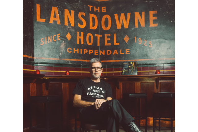 Mark Gerber sitting in front of a black and orange sign that readers 'the Lansdowne Hotel'